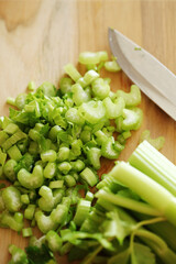 Fresh, sliced celery on a wooden cutting board