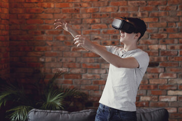 Teen playing with virtual reality glasses at home