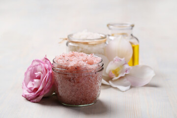 A glass jar of pink sea salt and flower for cosmetologic procedures