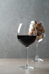 Wine cork stoppers in glass with red wine on a dark surface