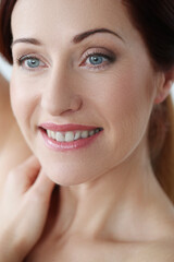 Obraz premium Close-up portrait of a beautiful,mature woman with blue eyes looking away and smiling
