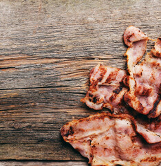 Hot fried bacon slices isolated on a wooden background