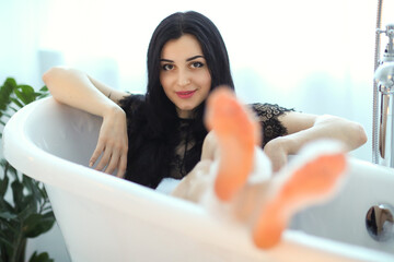 Obraz premium Close up a portrait of a young woman relaxing in a bathtub
