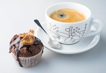 Cup of coffee with fig muffin isolated on white background