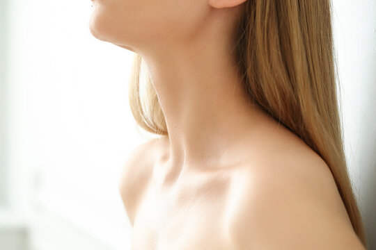 Сlose-up of a young blonde woman's neck on a white background