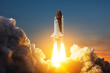 Spaceship lift off. Space shuttle with smoke and blast takes off into space on a background of sunset. Successful start of a space mission. Elements of this image furnished by NASA. - obrazy, fototapety, plakaty