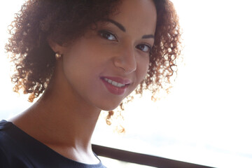 Close-up image of a smilng,beautiful woman with curly hair looking into the camera