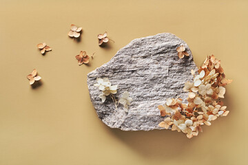 Rounded stone and dried flowers. Background for presentation of eco friendly and zero waste products in earth colors - obrazy, fototapety, plakaty