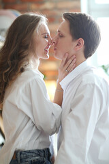 Photoshoot of a young couple of woman and man in white T-shirts at home