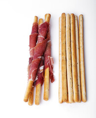 Delicious snacks with bacon and breadsticks isolated on a white background.