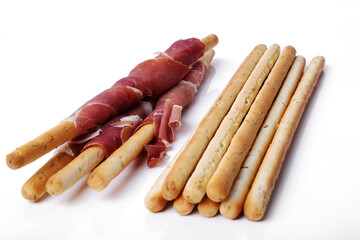 Delicious snacks with bacon and breadsticks isolated on a white background.