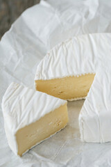 Fresh camembert cheese with sliced camembert isolated on a perchmanent paper.