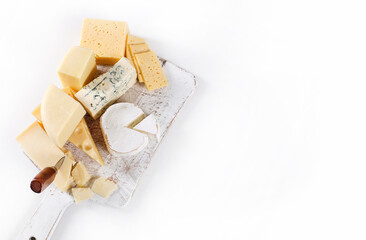 Different kinds of cheese isolated on a wooden cutting board.
