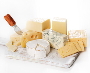 Different kinds of cheese isolated on a wooden cutting board.