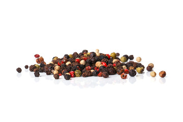 Black, red, white, and green peppercorns on a white background. 