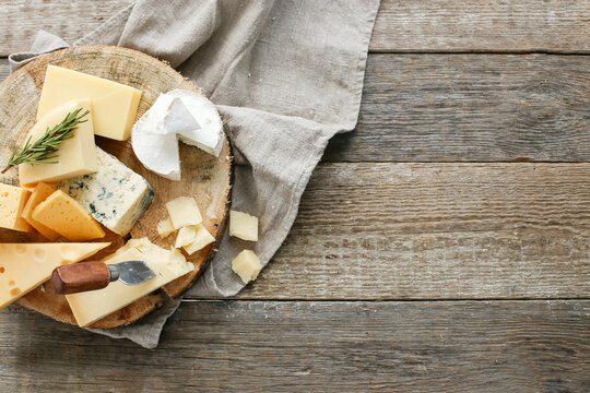 Different kinds of cheese isolated on a wooden surface.