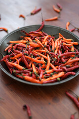 Fresh juicy red and yellow hot chili peppers isolated on a wooden background.
