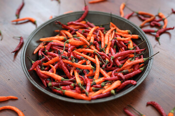 Fresh juicy red and yellow hot chili peppers isolated on a wooden background.