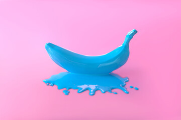 bright creative background with banana. spilled blue banana on a pink background. creative photo