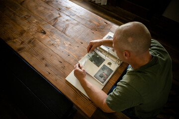 Marine veteran at home with family goes through uniforms and scrap book of military service.