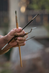 Artist's hand with brushes, spatula and other tools. Artist's tools. Hand with brushes and...