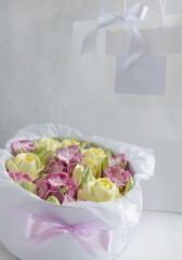 Marshmallow bouquet of flowers in a gift box on a light background, holiday concept