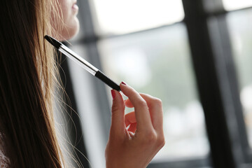 Close view of a young girl holding a pen.