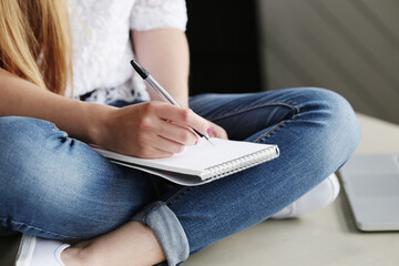 Woman`s hands holding a pen and notebook.
