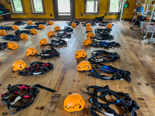 Row of helmets and harnesses ready for use at a high ropes and climbing course. 