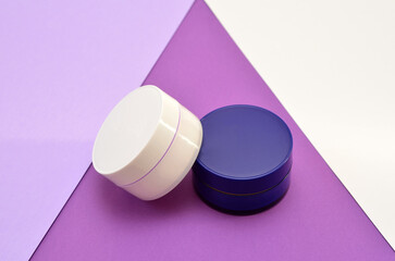 jars with cosmetics, beauty products on a lilac background close-up