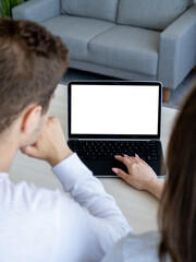 Online translation. Distance work. Computer mockup. Unrecognizable man and woman sitting desk with laptop blank screen in light room interior.