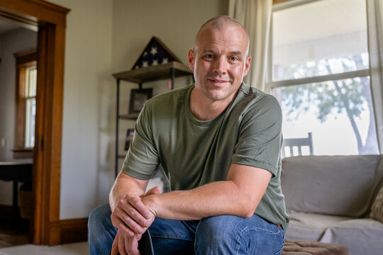 Marine veteran at home with family poses for portrait.