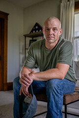 Marine veteran at home with family poses for portrait.