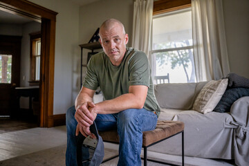 Marine veteran at home with family poses for portrait.