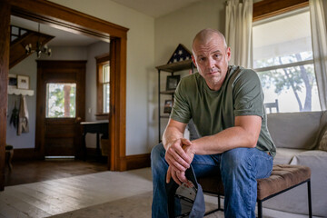 Marine veteran at home with family poses for portrait.