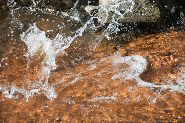 Clear water flow in a river on smooth stone stopped in motion 