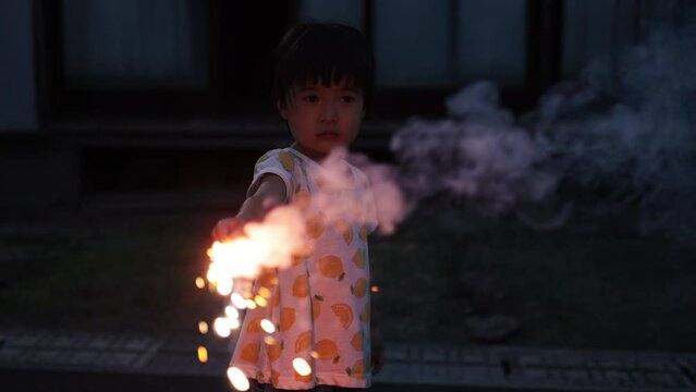 夏休みに家の庭で花火をしている女の子