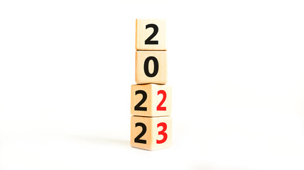 2023 happy new year symbol. Wooden cubes symbolize the change from 2022 to the new year 2023. Beautiful white table white background. Copy space. Business and 2023 happy new year concept.