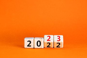 2023 happy new year symbol. Wooden cubes symbolize the change from 2022 to the new year 2023. Beautiful orange table orange background. Copy space. Business and 2023 happy new year concept.