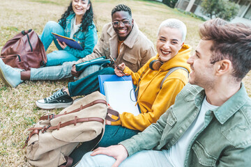 Group of multiracial students having fun sitting in college campus together - Happy teenagers hanging outside school - Millenial people laughing oudoors - Scholarship concept