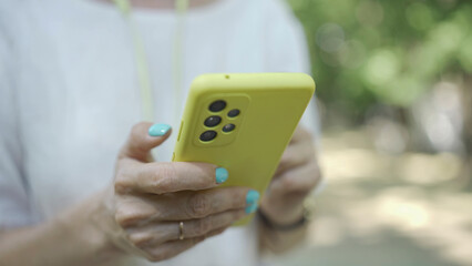 Close up of mature woman's hands use smartphone. Soft focus