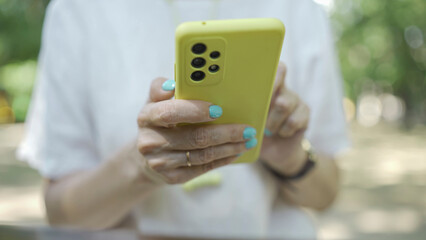 Close up of mature woman's hands use smartphone. Soft focus