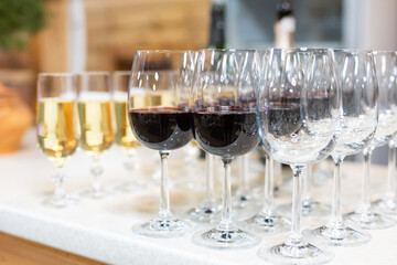 Many glasses of different wine in a row on bar counter