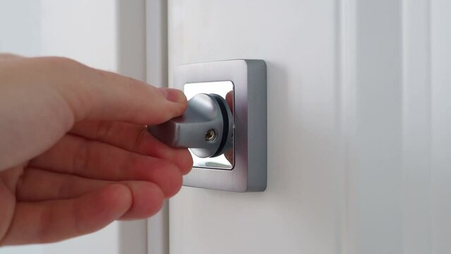 Check to open and close the door lock. Large door lock of the interior door. Female hand turns the lock