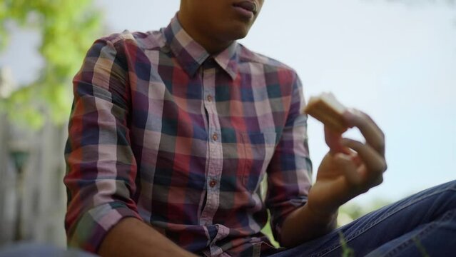 Closeup of young man suffering from stomach ache after eating a sandwich