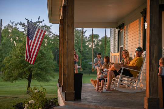 Marine veteran at home with family during sunset on front porch.