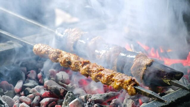 Close-up of eggplant kebab on skewers grilling on brazier. Turkish traditional kebabs grill on coal