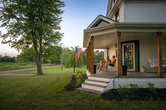 Marine veteran at home with family during sunset on front porch.
