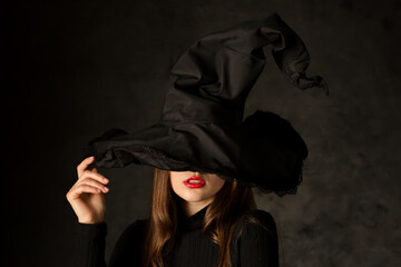 seductive young girl with red lipstick in witch hat