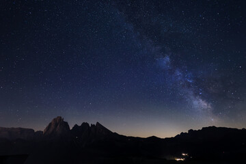 Milky Way over Alpe di Siusi or Seiser Alm) with Alps peaks Sassolongo and Sassopiatto on the left, Dolomites mountain, Sudtirol, Italy.